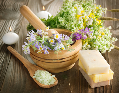 Holzlöffel und Mörser mit Salz und Blumen